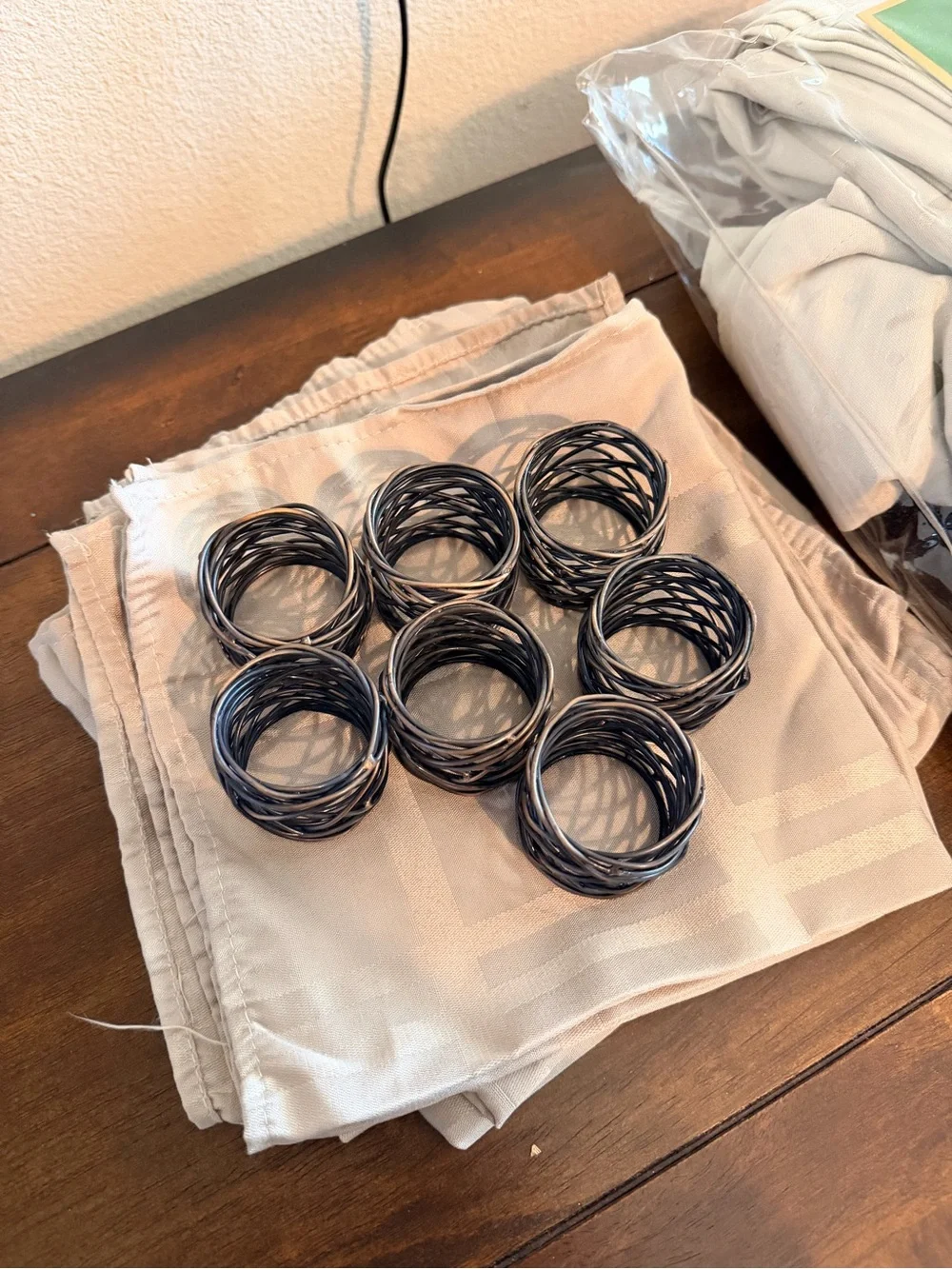Set of 7 Black bronze Twisted Napkin Rings & beige napkins